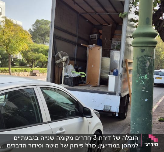 משאית פתוחה עם רהיטים וארגזים בתוכה